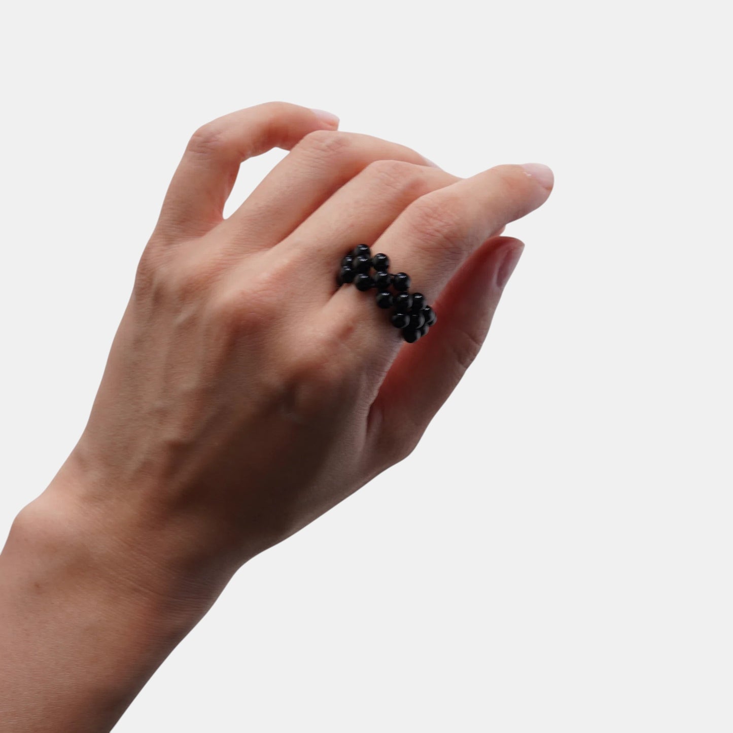 Hollywood Road Stories black beaded ring on a hand, featuring a multi-row woven design for a modern, elegant look.