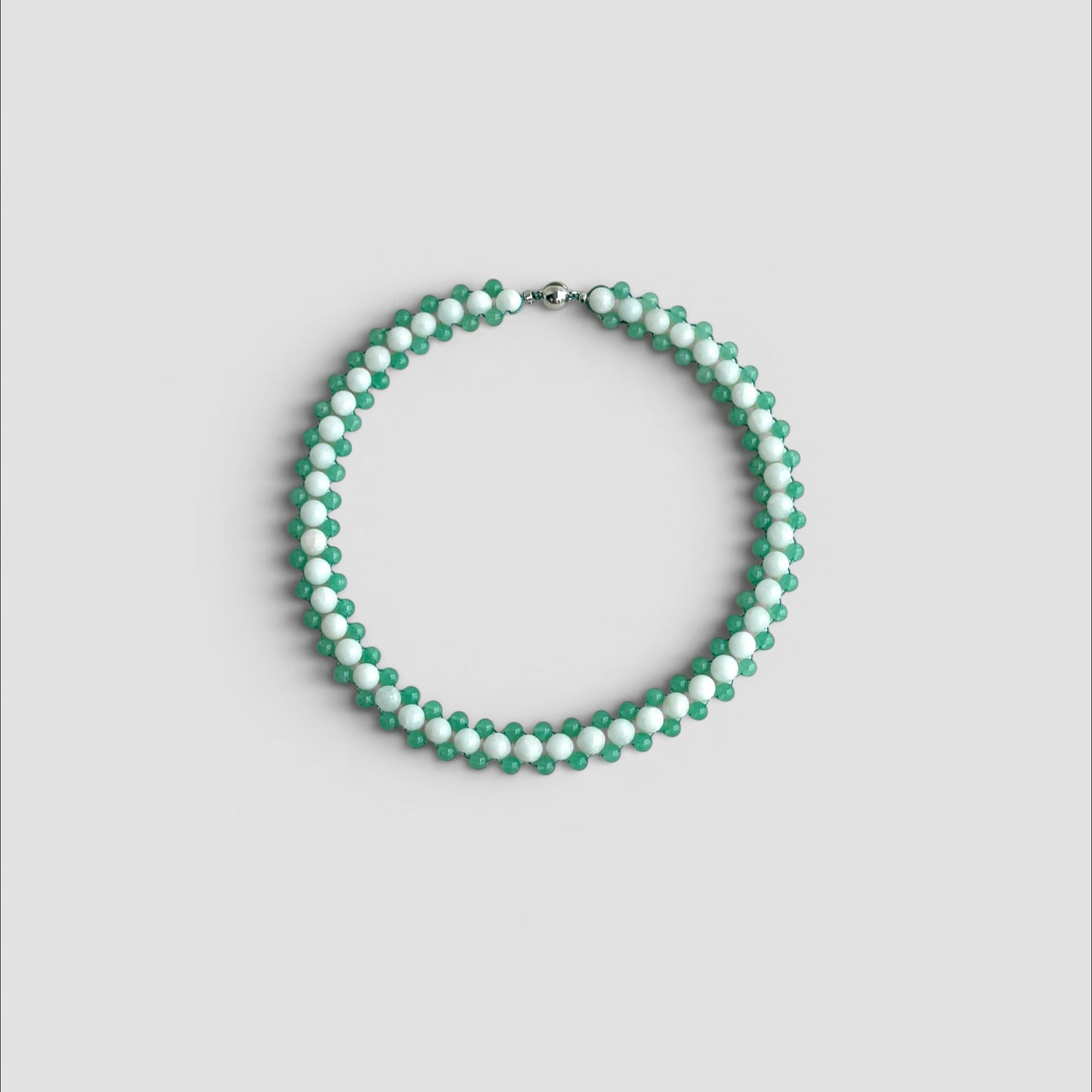 Hollywood Road Stories beaded choker necklace with alternating white and sage green beads in a woven pattern.