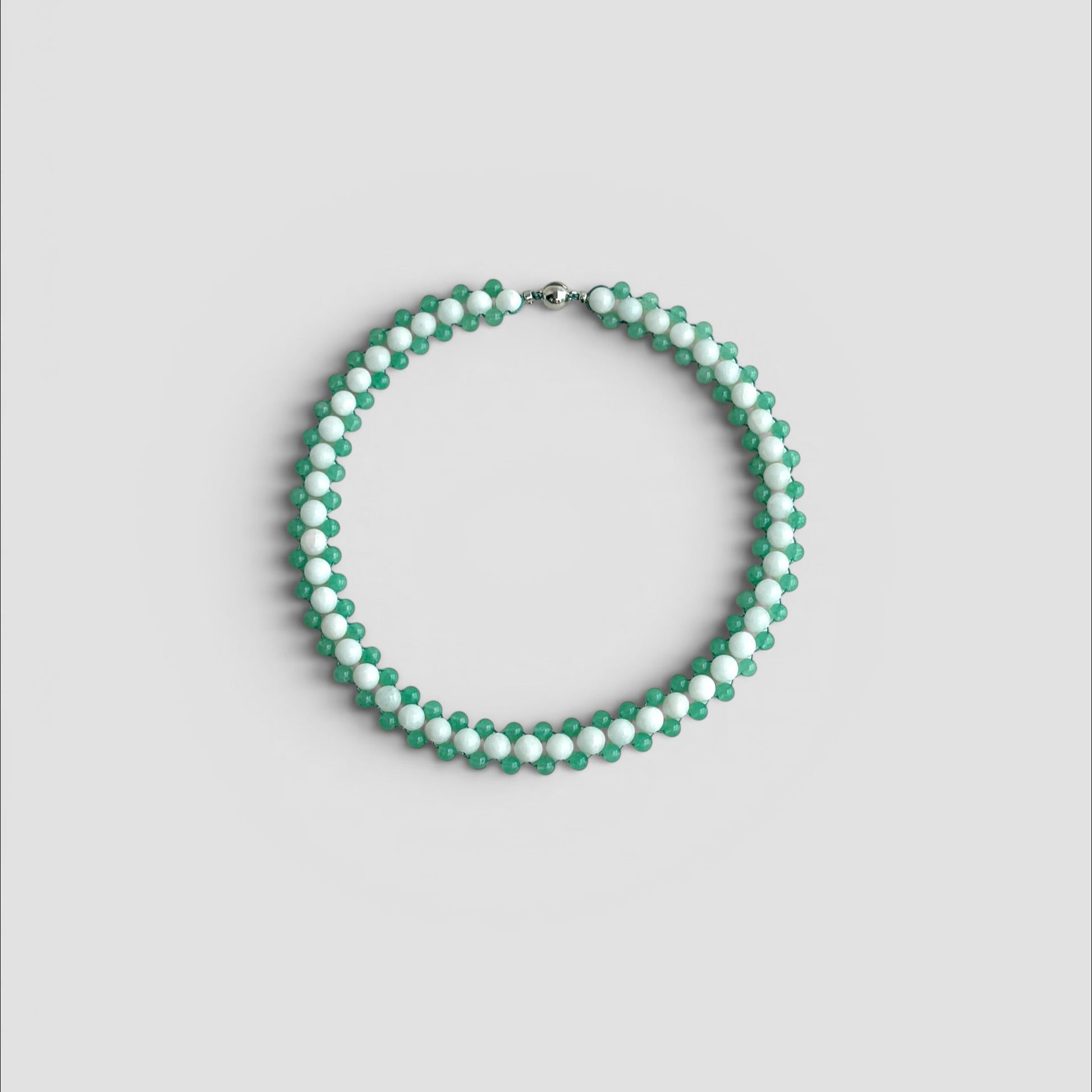 Hollywood Road Stories beaded choker necklace with alternating white and sage green beads in a woven pattern.