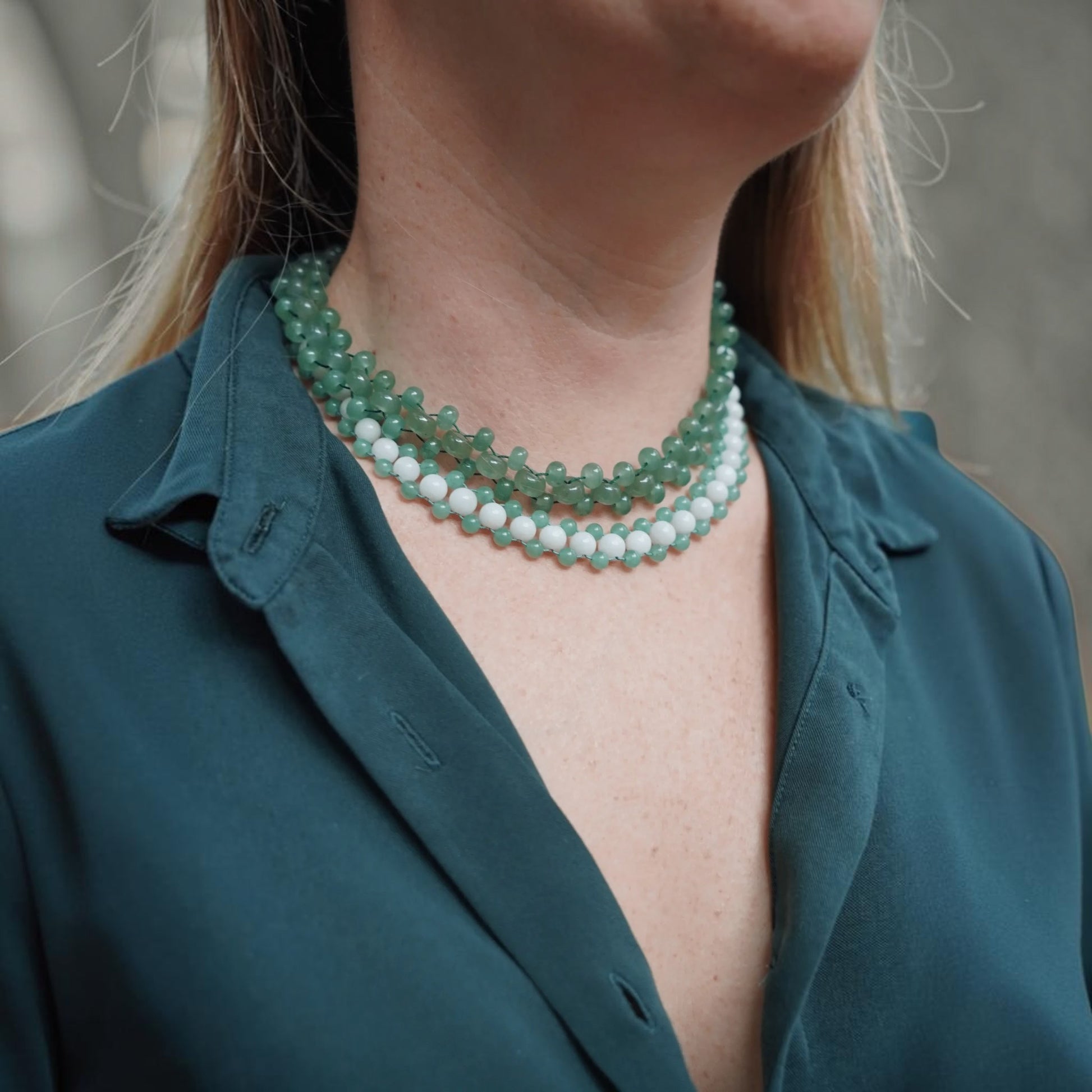 Hollywood Road Stories beaded choker with alternating sage green and white beads worn on a model in a dark green shirt.