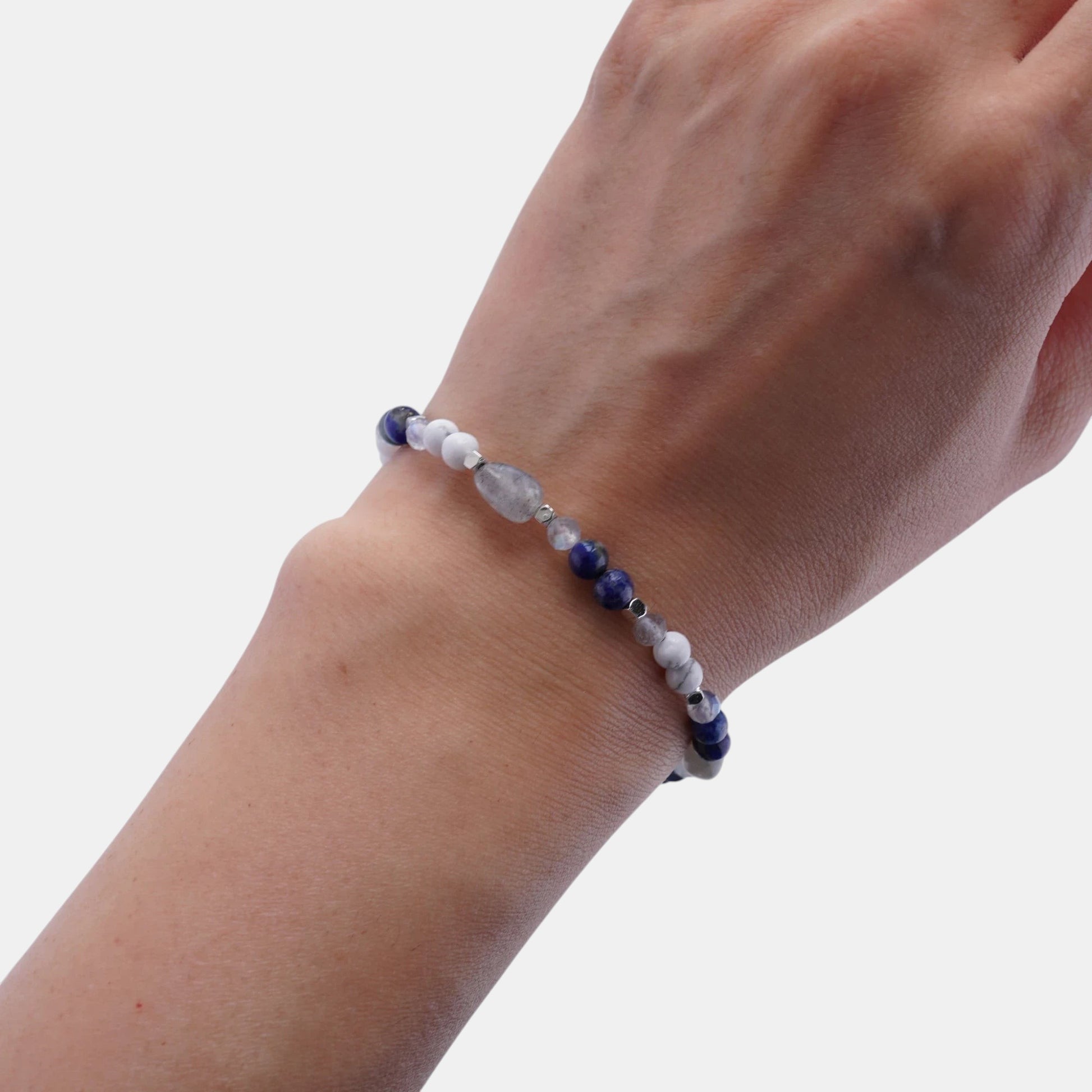 Hollywood Road Stories stretch bracelet with blue sodalite, white howlite, and grey moonstone beads on a wrist.