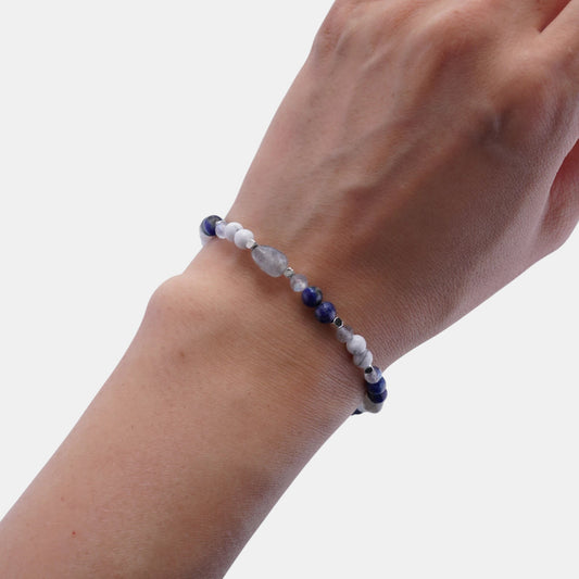 Hollywood Road Stories stretch bracelet with blue sodalite, white howlite, and grey moonstone beads on a wrist.