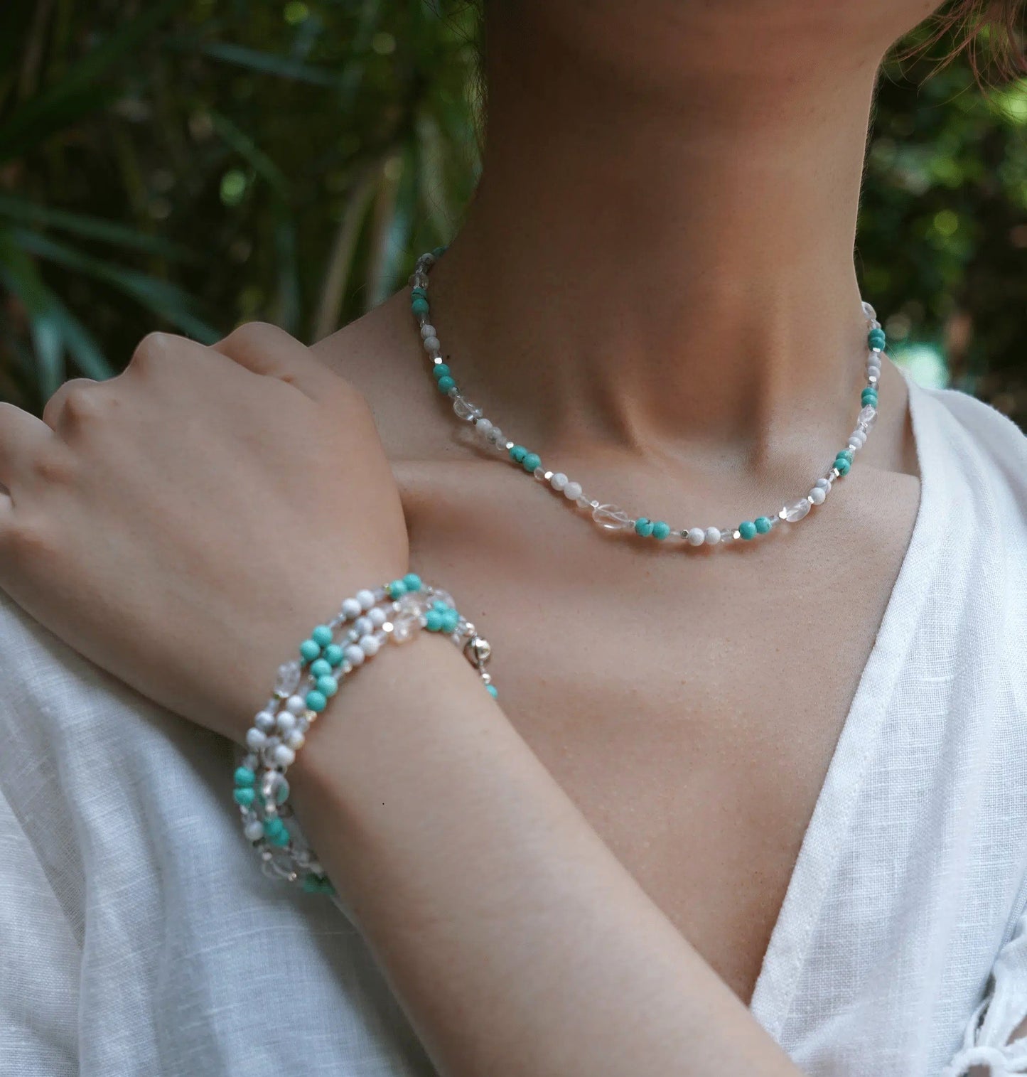 Hollywood Road Stories beaded necklace and bracelet set with turquoise, white, and crystal beads on a woman.