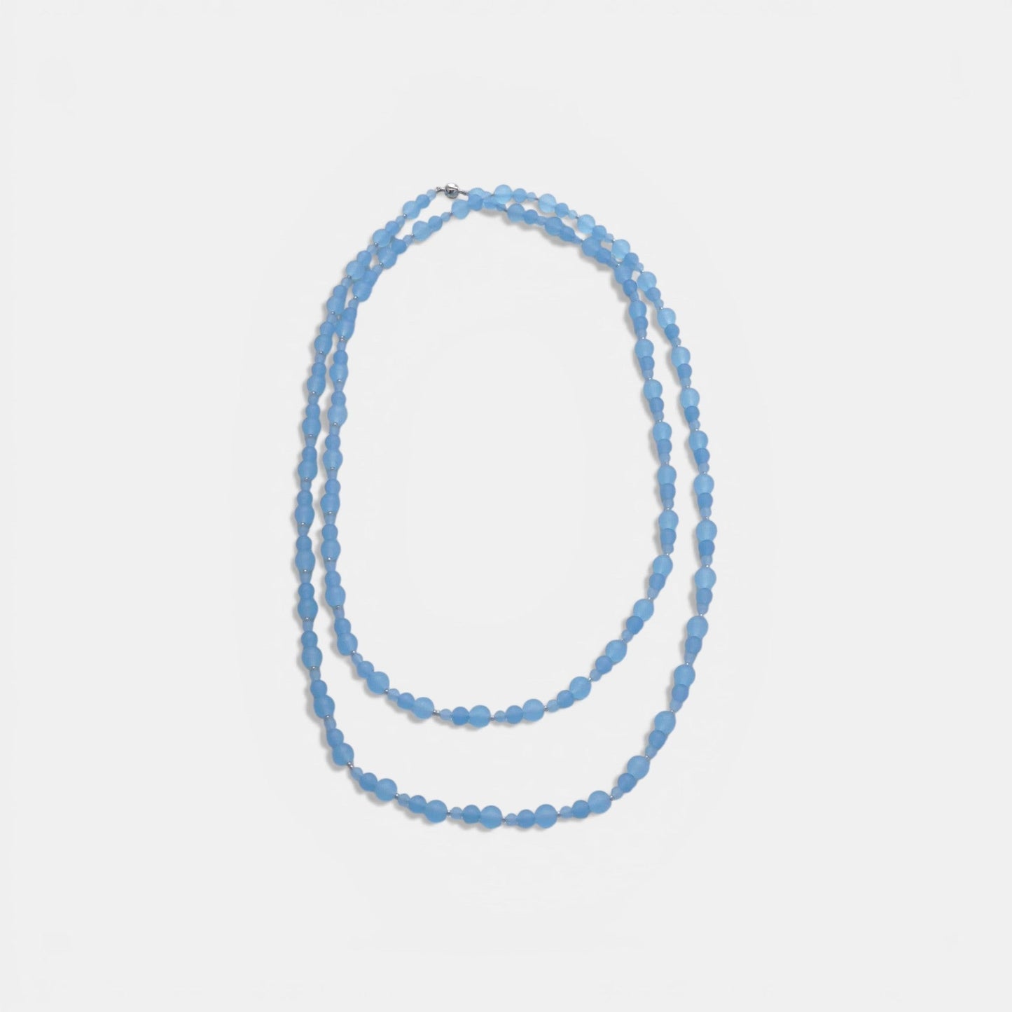 Hollywood Road Stories triple-strand frosted sky blue glass bead necklace with silver-toned spacers on a white background