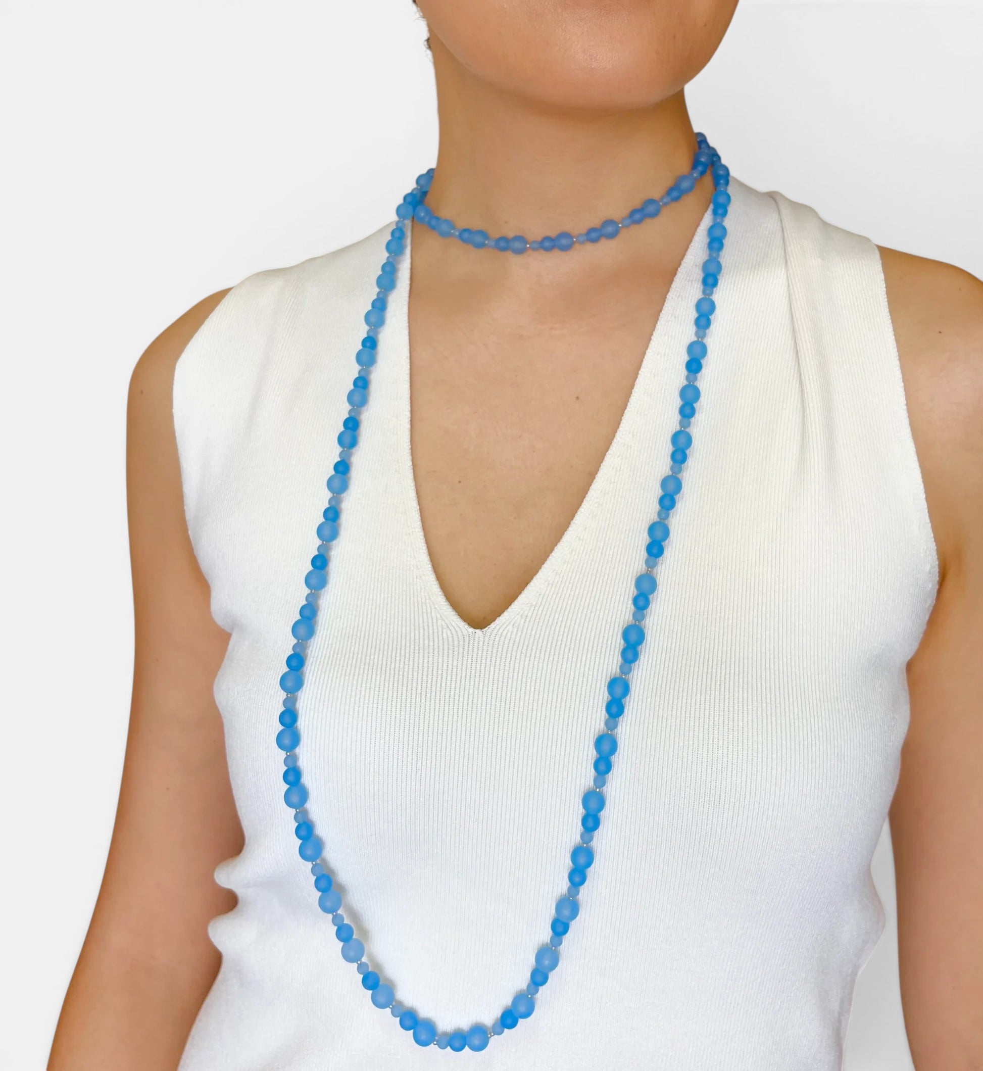Hollywood Road Stories Possession multi-strand necklace featuring slate blue chalcedony beads on a white top.