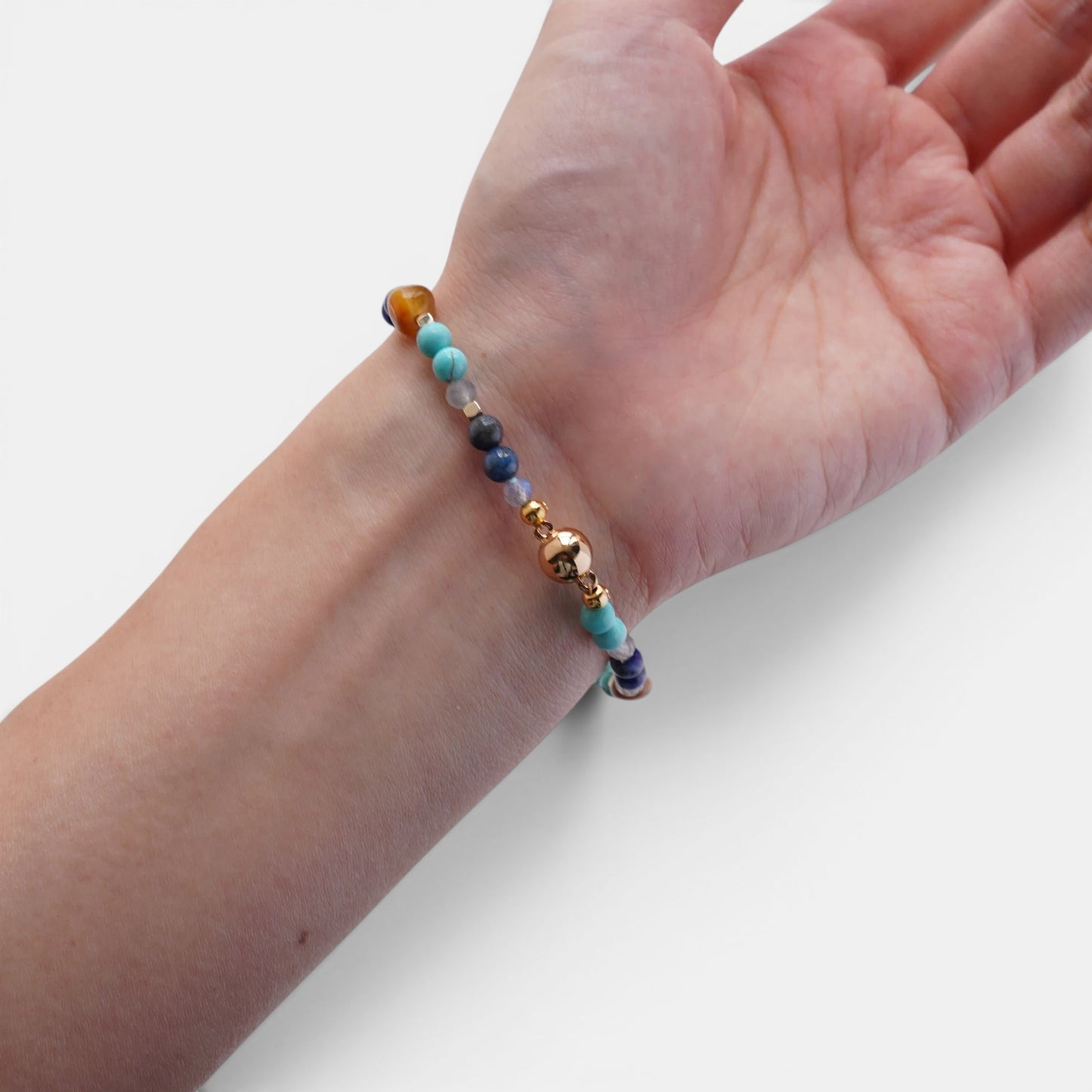 Hollywood Road Stories beaded bracelet with turquoise, lapis lazuli, and tiger's eye gemstones on a wrist.