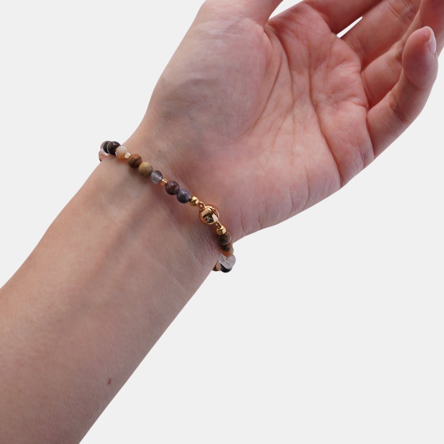Hollywood Road Stories stretch bracelet with natural gemstone beads in brown and pink with gold-tone accents on a wrist.