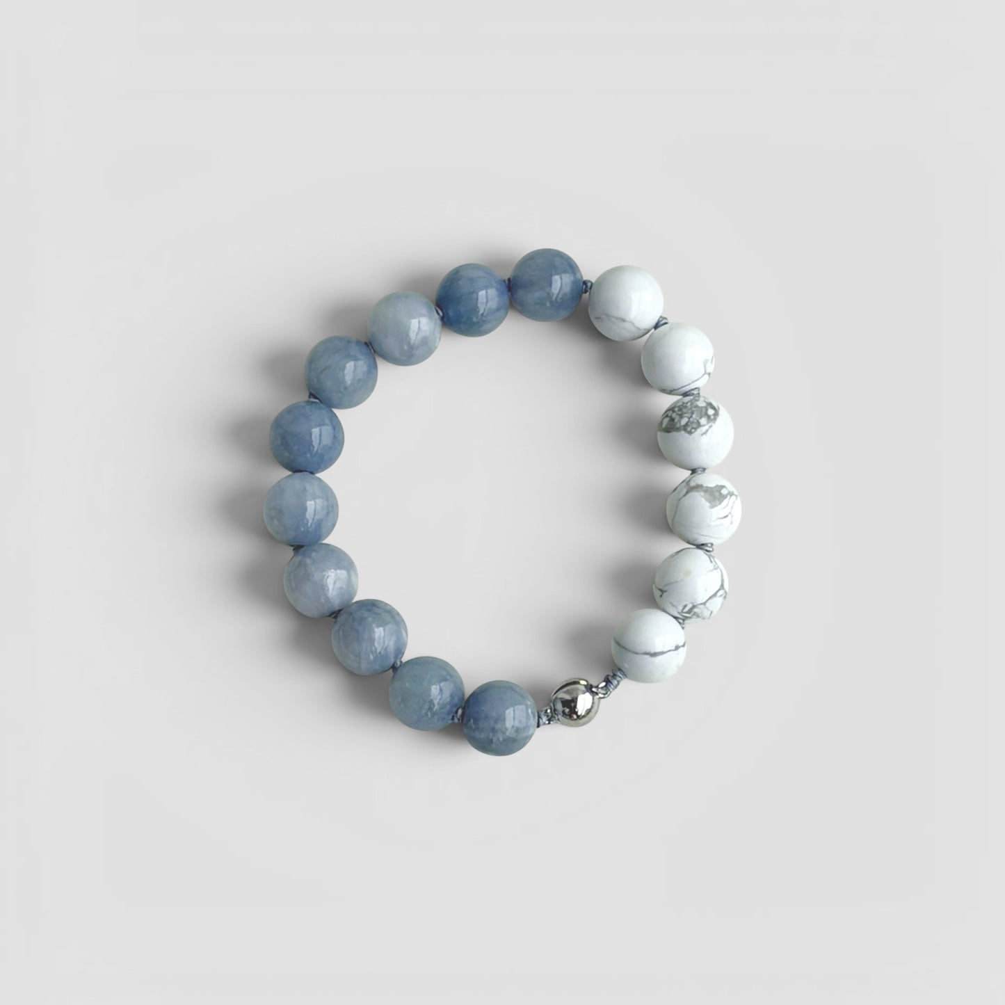 Hollywood Road Stories natural stone stretch bracelet with smooth grey and marbled white beads on elastic cord.