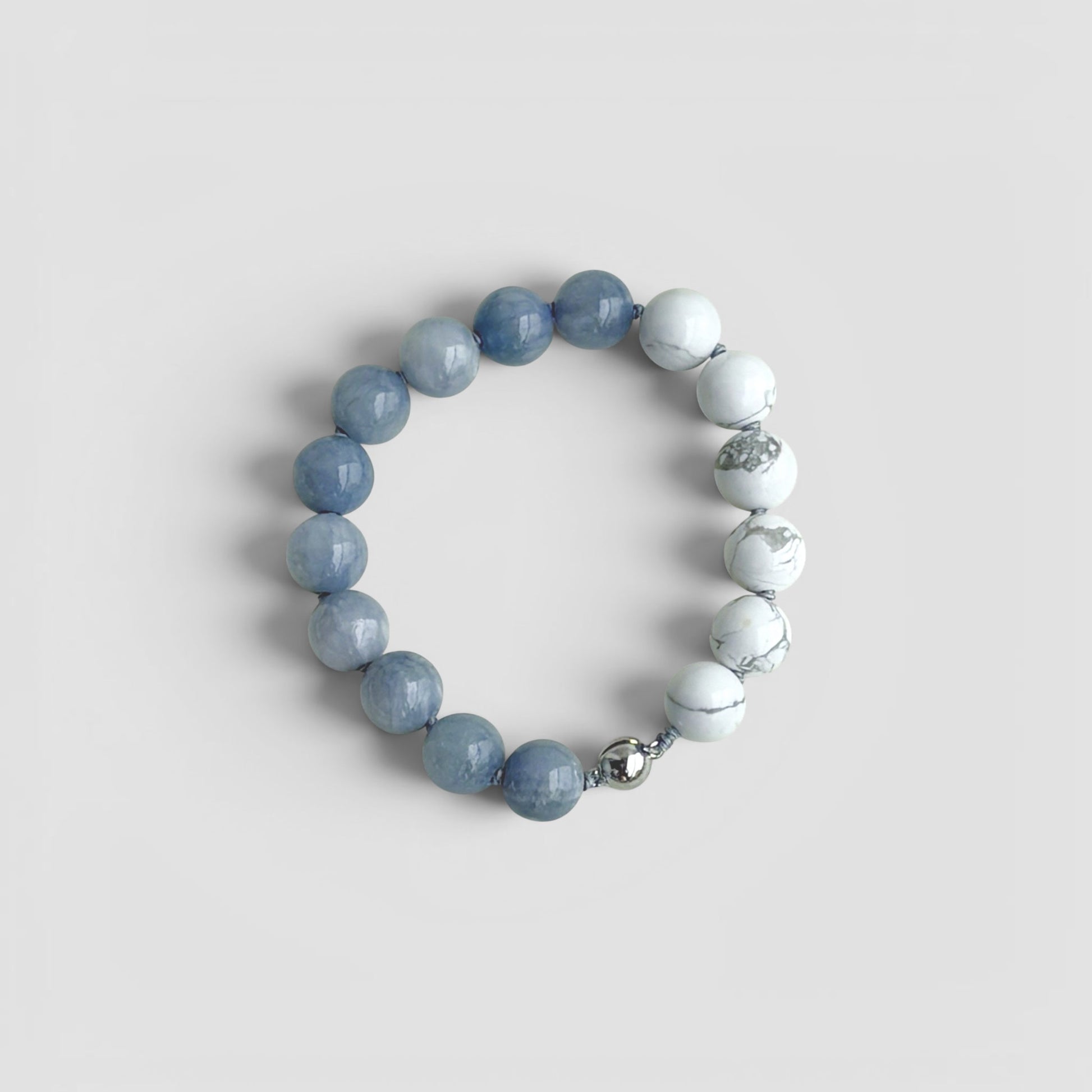 Hollywood Road Stories natural stone stretch bracelet with smooth grey and marbled white beads on elastic cord.
