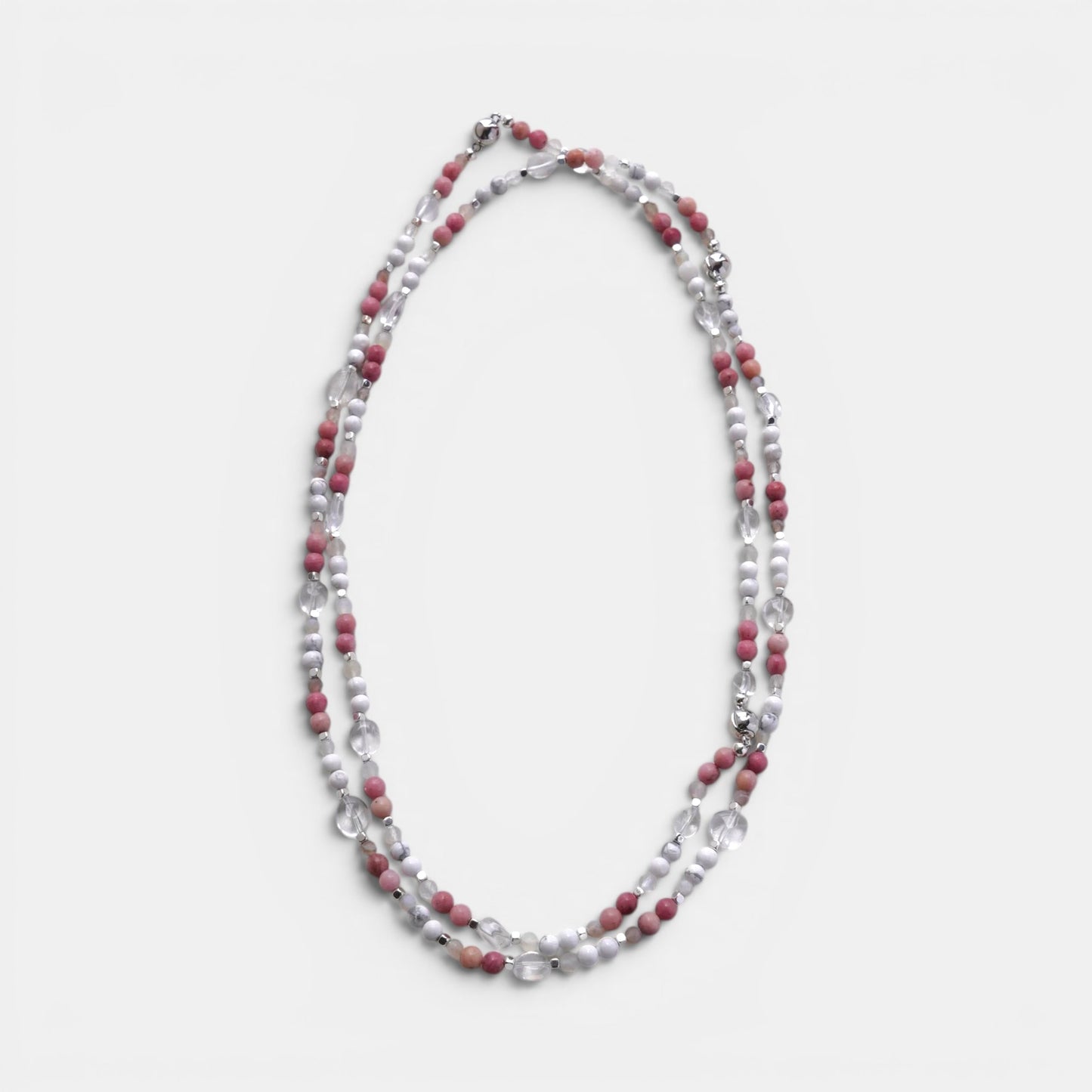 Hollywood Road Stories layered necklace with pink rhodonite, white howlite, and clear crystal beads on a white surface.