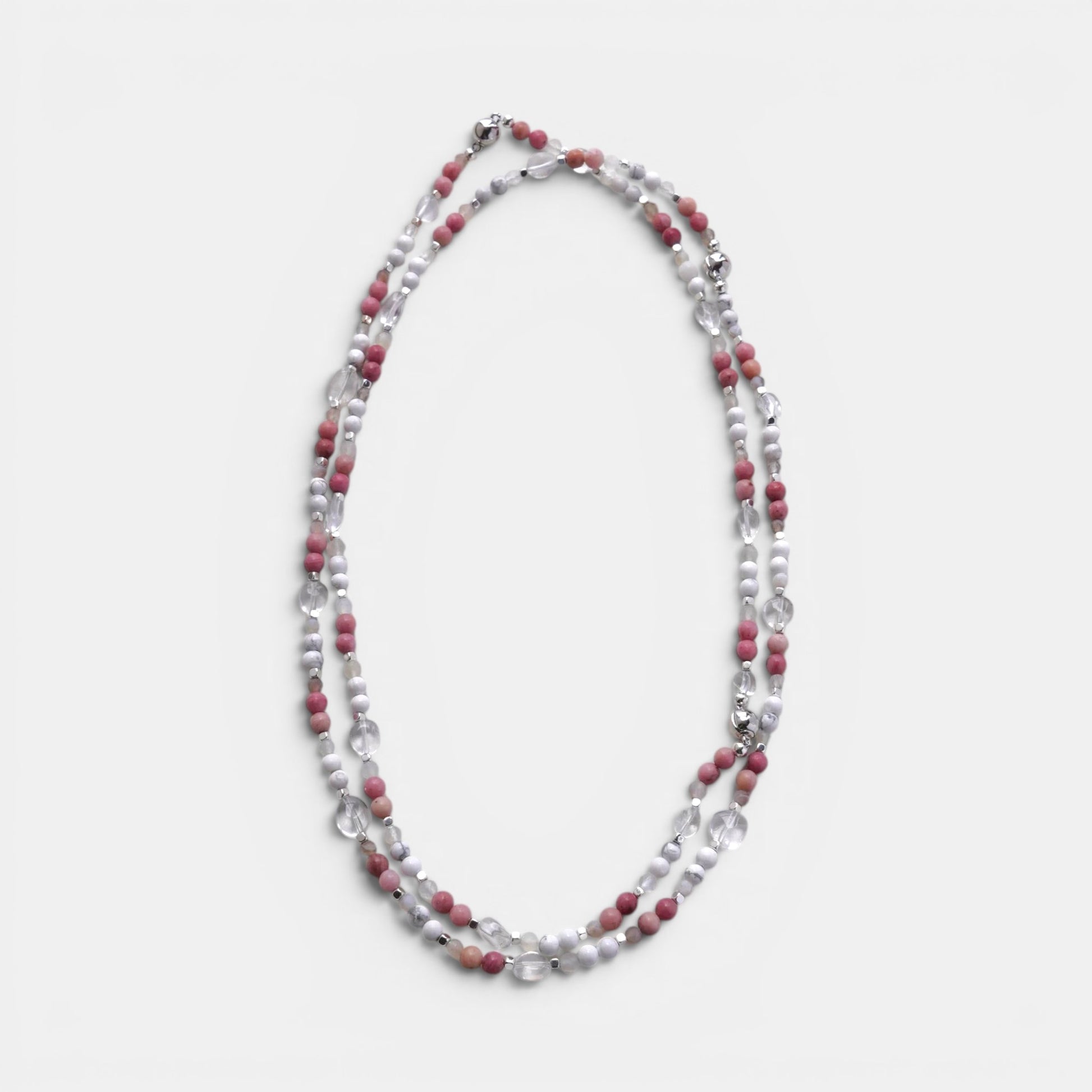 Hollywood Road Stories layered necklace with pink rhodonite, white howlite, and clear crystal beads on a white surface.