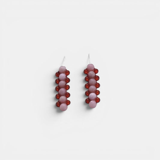 Hollywood Road Stories handcrafted drop earrings featuring vertical rows of pink and deep red beads on a white background