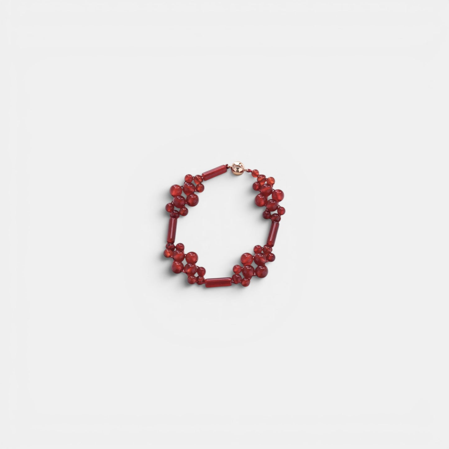 Hollywood Road Stories red beaded cluster bracelet with polished round and cylindrical beads on a white background.