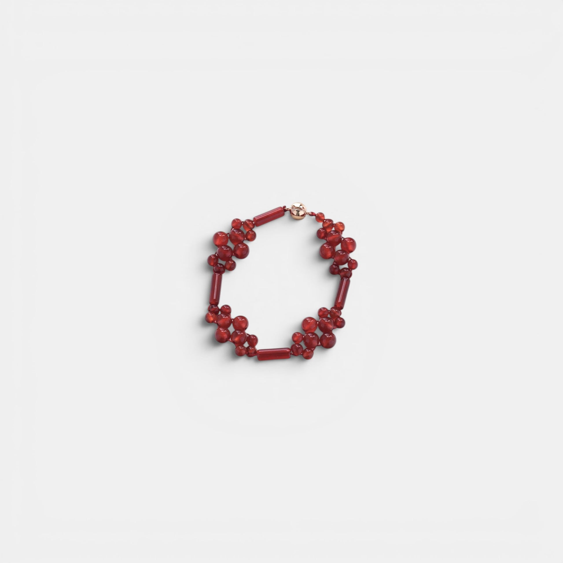Hollywood Road Stories red beaded cluster bracelet with polished round and cylindrical beads on a white background.