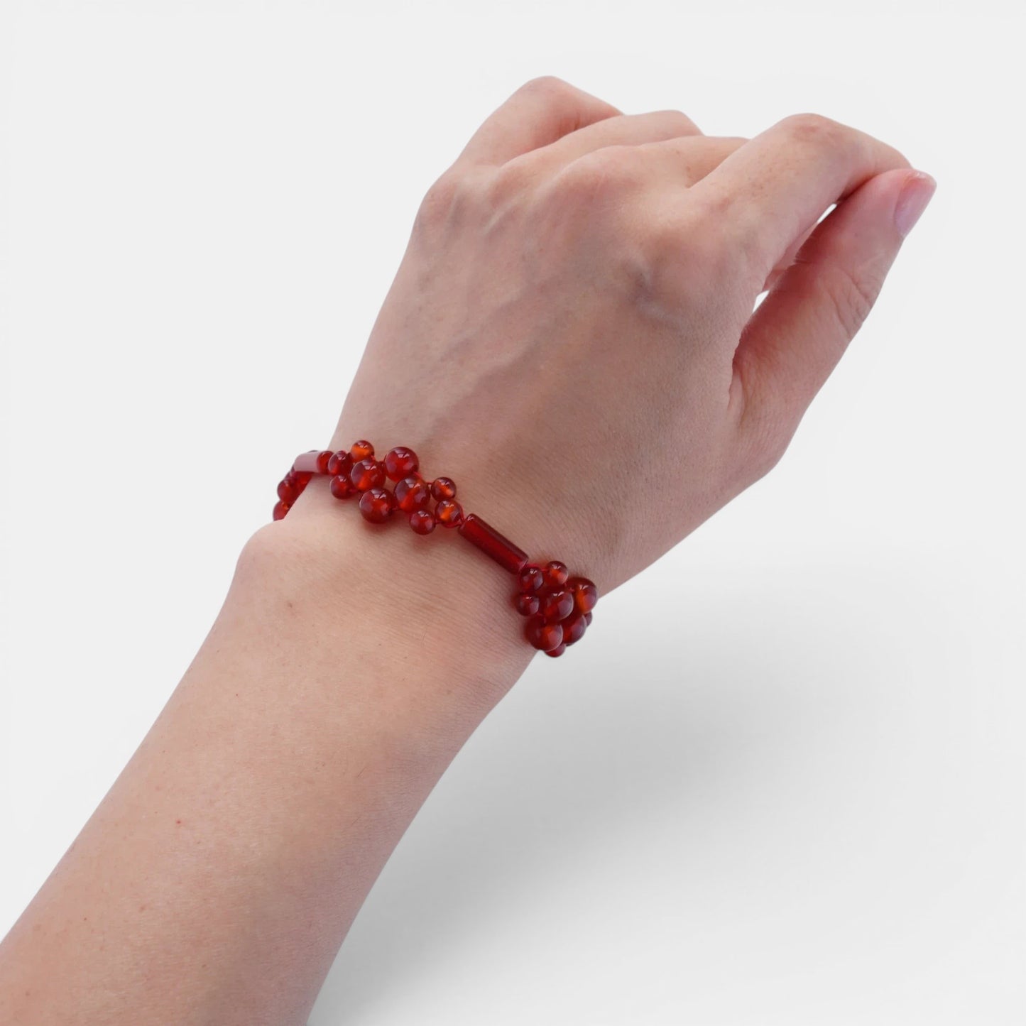Hollywood Road Stories red beaded cluster bracelet worn on a wrist, featuring polished deep red beads.