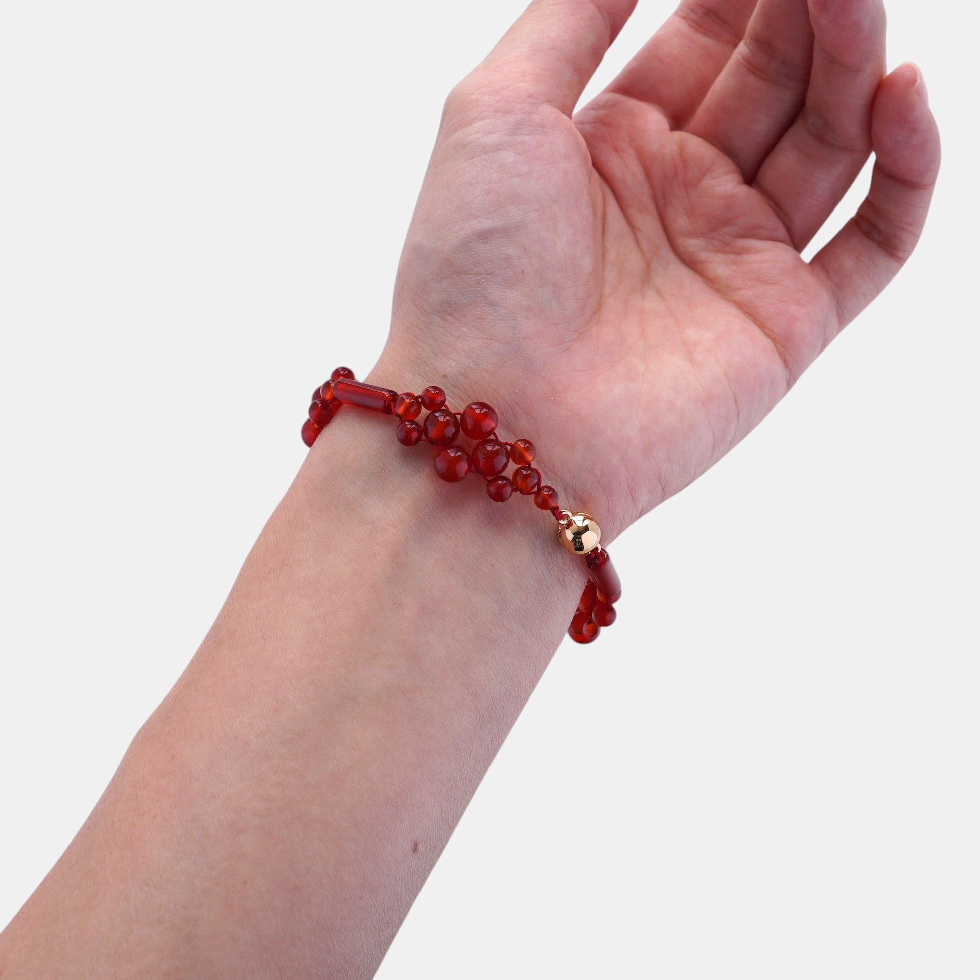 Hollywood Road Stories red beaded cluster bracelet with a gold accent bead worn on a wrist