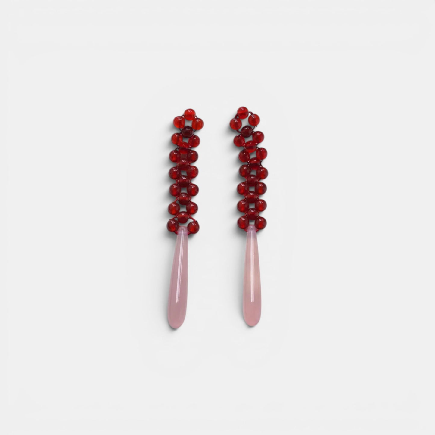 Hollywood Road Stories beaded drop earrings with deep red glass bead tops and smooth pale pink teardrop pendants.