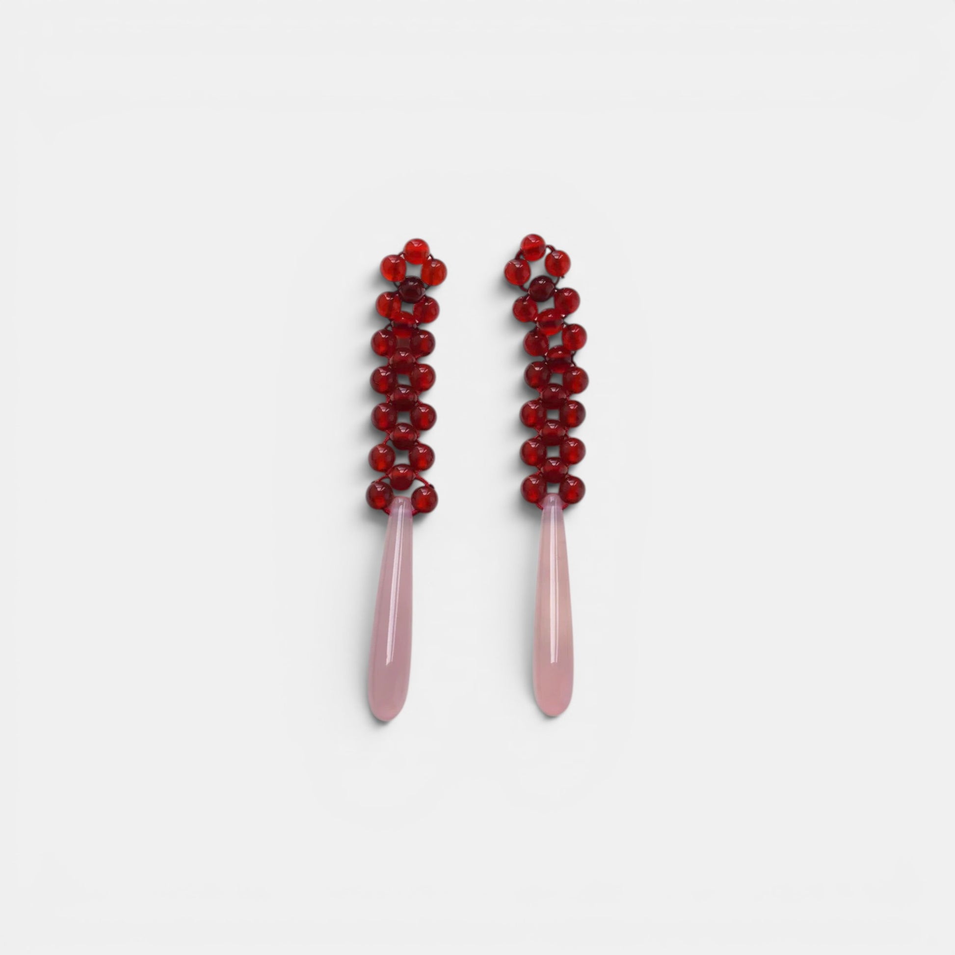 Hollywood Road Stories beaded drop earrings with deep red glass bead tops and smooth pale pink teardrop pendants.