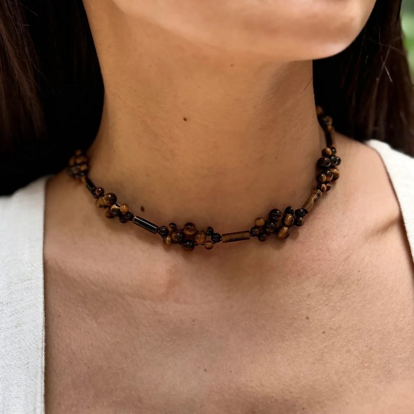Hollywood Road Stories tiger's eye beaded choker necklace featuring round and elongated stones on a woman's neck.