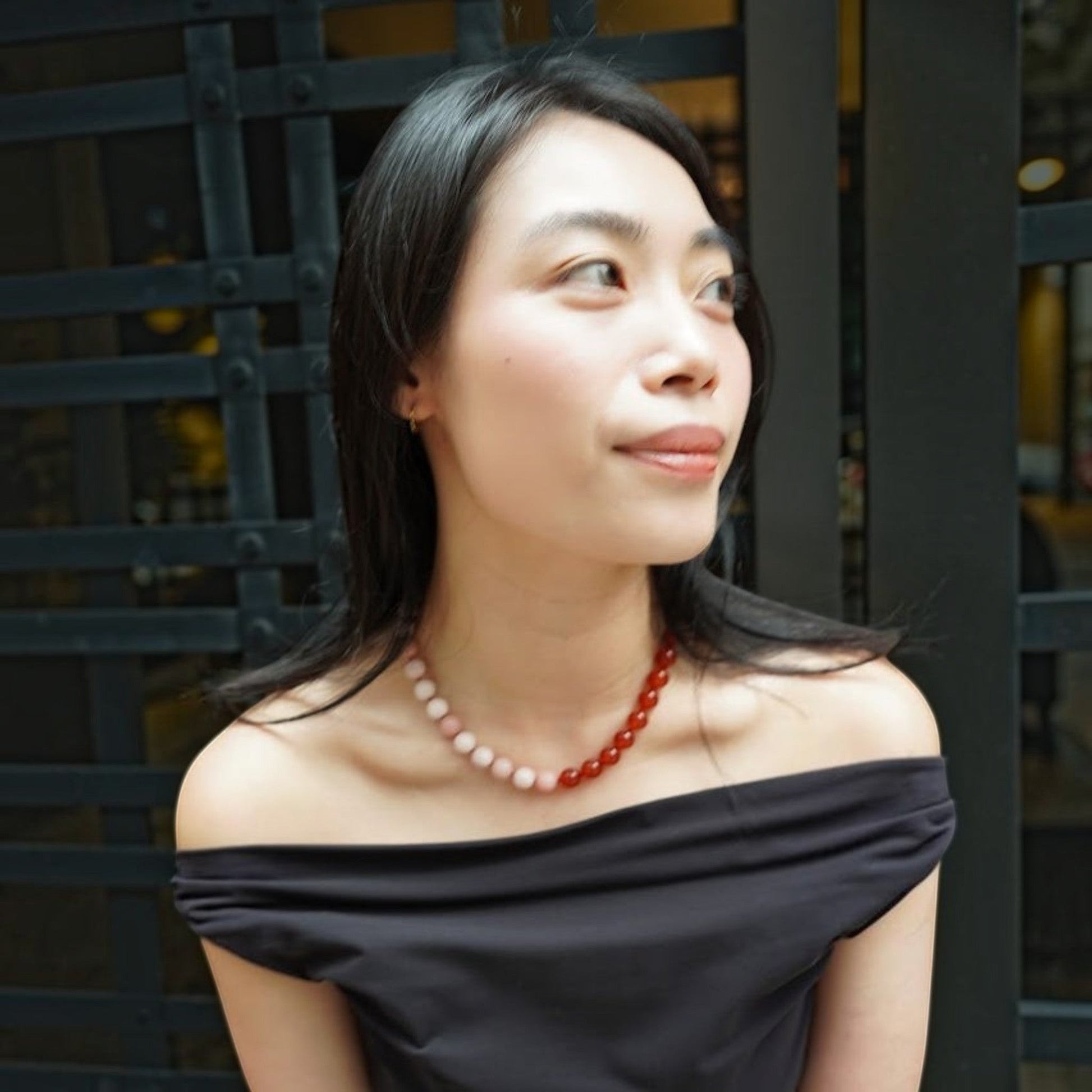Model wearing a Hollywood Road Stories carnelian and pink opal beaded necklace with a gold clasp